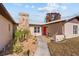 Home featuring stone column, red door, tidy landscaping, and inviting walkway at 11001 Hobson St, Spring Hill, FL 34608