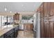 Stylish kitchen features dark wood cabinets, stainless steel appliances, granite countertops and a view to the outdoors at 11001 Hobson St, Spring Hill, FL 34608