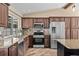 Well-equipped kitchen with dark cabinetry, stainless steel appliances, granite counters, and decorative backsplash at 11001 Hobson St, Spring Hill, FL 34608