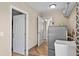 Functional laundry room features a utility sink, storage shelves, and wood look flooring at 11001 Hobson St, Spring Hill, FL 34608
