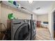 Well-equipped laundry room featuring modern appliances and light wood-look flooring at 11001 Hobson St, Spring Hill, FL 34608