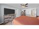 Spacious main bedroom featuring wood-look floors, a ceiling fan, and a large dresser with a mounted television at 11001 Hobson St, Spring Hill, FL 34608