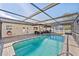 Inviting pool area with screened enclosure, lounge area, and private backyard views at 11001 Hobson St, Spring Hill, FL 34608