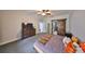Bedroom with soft carpet, ceiling fan, dresser, and large sliding door to the bathroom at 2160 Chianti Pl # 11-0117, Palm Harbor, FL 34683