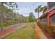 Red building exterior with a lush green wooded area behind the property at 2160 Chianti Pl # 11-0117, Palm Harbor, FL 34683