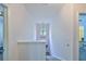 Upstairs hallway featuring neutral walls and carpeting, with a small arched window at 2160 Chianti Pl # 11-0117, Palm Harbor, FL 34683