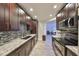 This kitchen has dark wood cabinets, granite counters, stainless steel appliances, and sleek subway tile backsplash at 2160 Chianti Pl # 11-0117, Palm Harbor, FL 34683