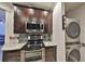 Contemporary kitchen featuring dark wood cabinets, stainless steel appliances, and in-unit laundry at 2160 Chianti Pl # 11-0117, Palm Harbor, FL 34683