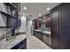 A modern kitchen with dark wood cabinets, stainless steel appliances, and granite countertops at 2160 Chianti Pl # 11-0117, Palm Harbor, FL 34683