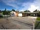 Exterior view of a single-story home featuring a gated driveway and a carport at 3916 W Oklahoma Ave, Tampa, FL 33616
