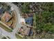 Aerial view of property highlighting the home's layout, screened-in pool, and location within a wooded neighborhood at 587 Lakewood Dr, Oldsmar, FL 34677