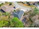 Overhead shot of a private residence in a wooded suburban neighborhood featuring a screened-in pool at 587 Lakewood Dr, Oldsmar, FL 34677