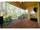 Inviting back patio featuring brick pavers, ceiling fan, and scenic view of trees at 587 Lakewood Dr, Oldsmar, FL 34677