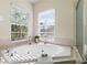 Bathroom showcasing a garden tub with jets, window views, and tile surround at 587 Lakewood Dr, Oldsmar, FL 34677