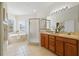 Bright bathroom with a glass-enclosed shower, double vanity, and a corner soaking tub at 587 Lakewood Dr, Oldsmar, FL 34677