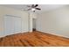 Neutral bedroom featuring hardwood floors, double door closet, and natural light from nearby window at 587 Lakewood Dr, Oldsmar, FL 34677