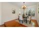 Cozy dining area with hardwood floors, plantation shutters, a modern chandelier, and a dining set for four at 587 Lakewood Dr, Oldsmar, FL 34677