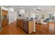 Open-concept kitchen with a granite island, stainless steel appliances, and hardwood floors throughout at 587 Lakewood Dr, Oldsmar, FL 34677