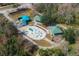 Ariel view of a community playground with covered picnic areas and a splash pad, surrounded by trees at 587 Lakewood Dr, Oldsmar, FL 34677