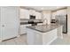 Kitchen featuring a large island with sink, stainless steel appliances, and white cabinetry at 6180 Apple Snail Ave, New Port Richey, FL 34653