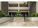 An exterior view showcasing the elegant entrance to Chateau Tower featuring lush landscaping at 7050 Sunset S Dr # 208, South Pasadena, FL 33707