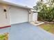 Spacious two-car garage with a paved driveway and exterior lighting at 9334 Ledgestone Ln, Port Richey, FL 34668