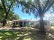 Charming one-story home featuring mature trees, brick accents, and a cozy covered porch entrance at 3009 Jim Johnson Rd, Plant City, FL 33566