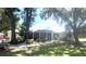 Charming single-story home with well-maintained lawn, mature trees, and inviting turquoise front door at 3009 Jim Johnson Rd, Plant City, FL 33566