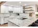 Modern kitchen featuring white cabinetry, granite countertops, stainless steel appliances and wood look tile flooring at 3009 Jim Johnson Rd, Plant City, FL 33566