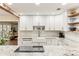 Bright kitchen with white cabinets, granite counters, farmhouse sink and a decorative backsplash at 3009 Jim Johnson Rd, Plant City, FL 33566
