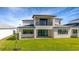 Home's backyard with ample green space, a covered patio, and a second story balcony overlooking the yard at 8421 Golden Beach Ct, Parrish, FL 34219