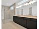 Modern bathroom featuring double sinks with gold fixtures and a glass shower at 8421 Golden Beach Ct, Parrish, FL 34219