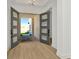 Light-filled entryway featuring wood floors, modern grey doors, and a glimpse of the exterior pavers at 8421 Golden Beach Ct, Parrish, FL 34219