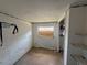 Bedroom with peeling paint, boarded window, and built-in shelving, needing updates at 14236 Palm St, Madeira Beach, FL 33708