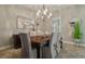 An elegant dining room featuring a wood table, six chairs, chandelier lighting, and decorative plants at 21812 Emory Oak Pl, Land O Lakes, FL 34637