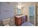 Well-lit bathroom featuring a dual sink vanity, marble floors, and updated fixtures, with a separate toilet area at 2424 W Tampa Bay Blvd # B201, Tampa, FL 33607