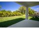 View from covered patio of lush backyard with manicured lawn and privacy landscaping at 11892 Richmond Trl, Parrish, FL 34219