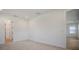 Bright, carpeted bedroom with a view, featuring white walls, trim, and a door to the hallway at 11892 Richmond Trl, Parrish, FL 34219