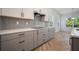 Updated kitchen design features sleek gray cabinets, subway tile backsplash, and stainless steel appliances at 11892 Richmond Trl, Parrish, FL 34219