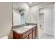 Bathroom featuring a granite countertop and large mirror with wood cabinets at 13456 Marble Sands Ct, Hudson, FL 34669