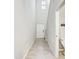 Bright hallway featuring tiled flooring, a stairway, and a glimpse of a bathroom, providing a sense of spaciousness at 13456 Marble Sands Ct, Hudson, FL 34669