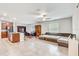 Open-concept living and dining area boasting tile floors, a ceiling fan, and a large sectional couch at 13456 Marble Sands Ct, Hudson, FL 34669