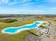 Beautiful aerial view of lagoon with sandy beach, clubhouse and homes in planned community at 17071 Oval Rum Dr, Wimauma, FL 33598