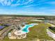 Stunning aerial view of the community lagoon and surrounding neighborhood on a sunny day at 17071 Oval Rum Dr, Wimauma, FL 33598
