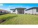 Lush green backyard featuring a screened-in patio, white fence, and manicured landscaping at 1975 Pepper Grass Dr, North Port, FL 34289