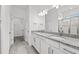 Bathroom with double granite vanity, white cabinetry, and a glass shower at 1975 Pepper Grass Dr, North Port, FL 34289