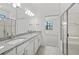 Bathroom with double vanity, granite countertops, and glass-enclosed shower at 1975 Pepper Grass Dr, North Port, FL 34289