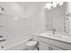 Bright bathroom features white cabinets, white tub, shower, and toilet at 1975 Pepper Grass Dr, North Port, FL 34289