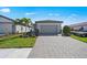 Beautiful single-Gathering home with well-kept lawn, palm tree, paved driveway, and two-car garage at 1975 Pepper Grass Dr, North Port, FL 34289