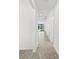 Bright hallway with light gray tile floors leads to the living area with dark framed sliding glass doors at 1975 Pepper Grass Dr, North Port, FL 34289